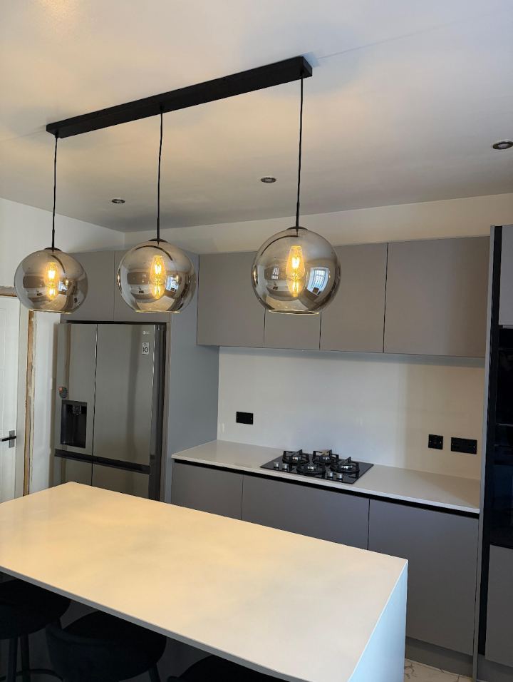 Three pendant lights over a kitchen island, installed by DMC Electric